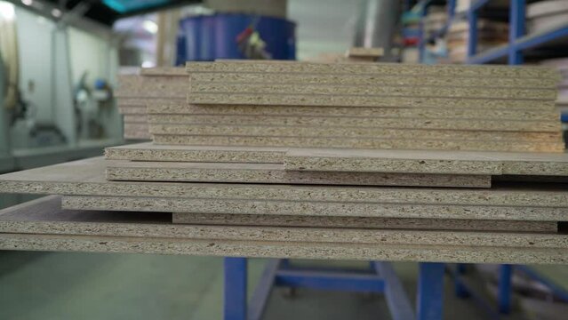 A stack of chipboard sheets in the furniture industry. Wooden parts or panels. A stack of wood sheets for furniture production are on the workbench.