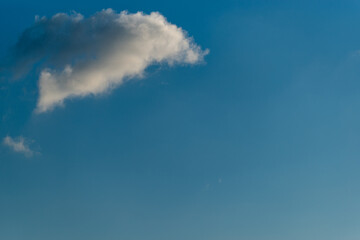 Fototapeta na wymiar bright blue summer sky with a dark cloud in the upper left corner 
