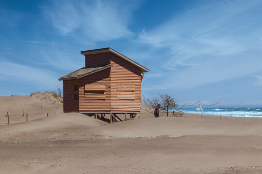 Hombre solitario en su casa a la orilla del mar