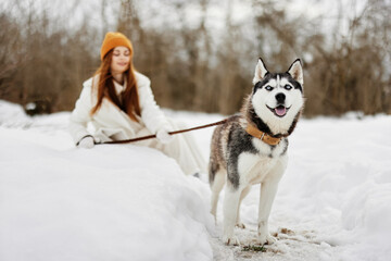 young woman winter clothes walking the dog in the snow Lifestyle