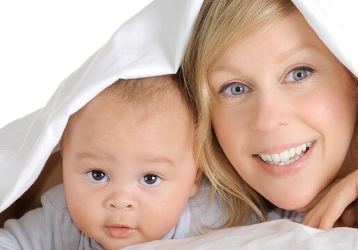 baby with his mother been cared for after having a good night sleep in bed at home stock photo