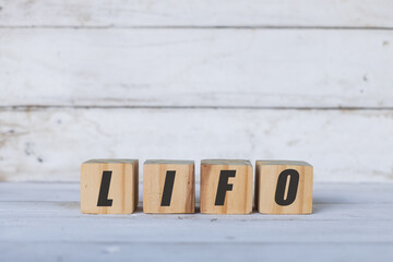 LIFO concept written on wooden cubes or blocks, on white wooden background.