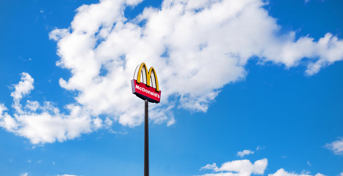 Germany - MAR 19, 2022: Mcdonalds sign in front of a blue sky with white clouds