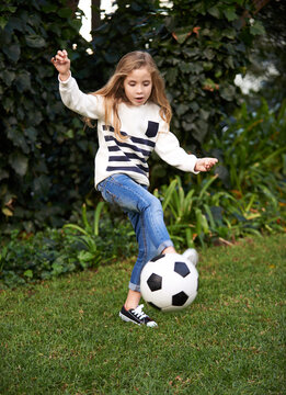 Shes got some skill. Shot of a little girl playing with a soccer ball in a garden.