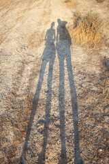 Shadow of man and woman holding hands together on the mountain. High quality photo