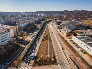 A street with a roundabout and apartment blocks on a sunny day in Gdańsk.