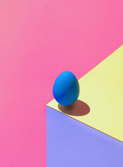 Modern optical illusion made of Easter egg on colorful background. 3D render blue egg on paper...