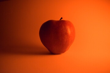 THIS IS A RED APPLE IN A BEGRAUND WITH WARM LIGHT
