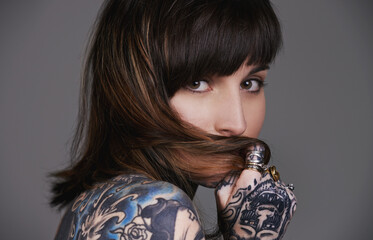 Tattoos say who I am without having to speak. A cropped studio portrait of a beautiful tattooed...