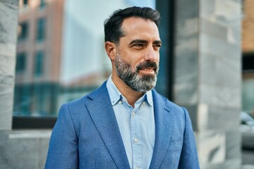 Fototapeta premium Middle age businessman smiling happy standing at the city.