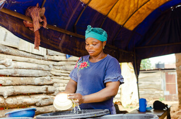 Matured African woman washing dish in a local food restaurant