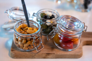 Glass jars with healthy party snacks served in bar, tasty appetisers