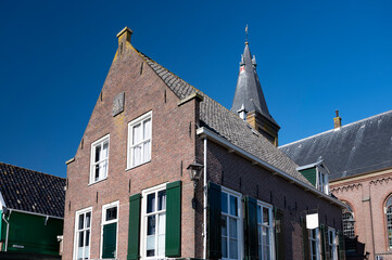 Walking on sunny day in small Dutch town Marken with wooden houses located on former island in North Holland, Netherlands