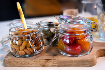 Glass jars with healthy party snacks served in bar, tasty appetisers