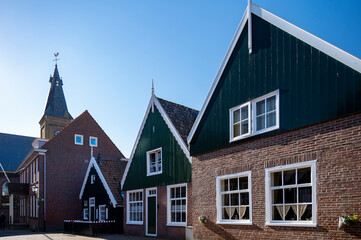 Walking on sunny day in small Dutch town Marken with wooden houses located on former island in North Holland, Netherlands