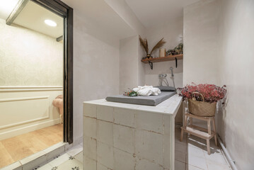 Hamman sauna with tile table and hot stones to release steam, shelves and cushions and wooden shelf with accessories