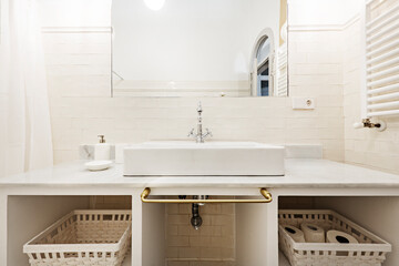 White porcelain sink on white marble countertop with recessed mirrors and vintage chrome faucet