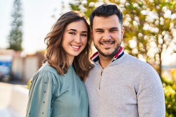 Man and woman smiling confident hugging each other standing at park