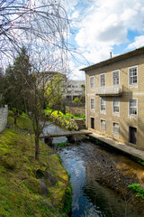 Fototapeta premium Building on river margins. City river on Portugal in the city of Braga