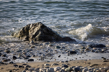 small waves rolling stones on pebble beach