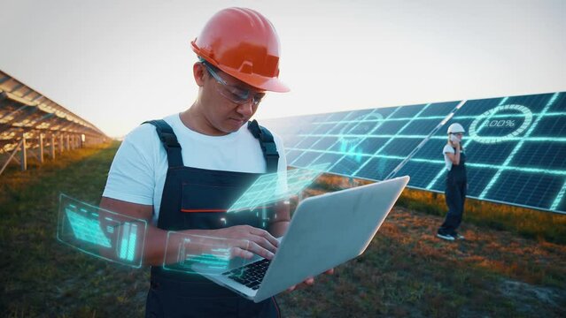 Engineer or construction worker asian man uses laptop to check solar panel system status. Cell power plant. Augmented reality concept. Futuristic technology
