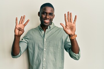 Young african american man wearing casual clothes showing and pointing up with fingers number nine...