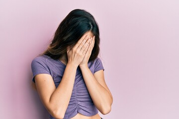 Young caucasian woman wearing casual clothes with sad expression covering face with hands while crying. depression concept.