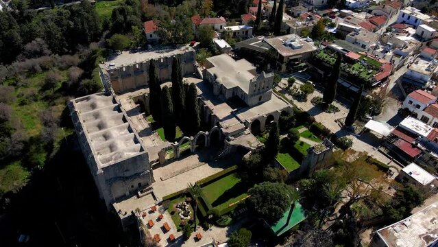 Aerial 4K view of beautiful Bellapais Village with Bellapais Monastery in Kyrenia, North Cyprus surrounded with an amazing green Mediterranean nature and picturesque landscapes in Cyprus.
