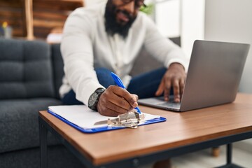 Young african american man psychologist using laptop at psychology center