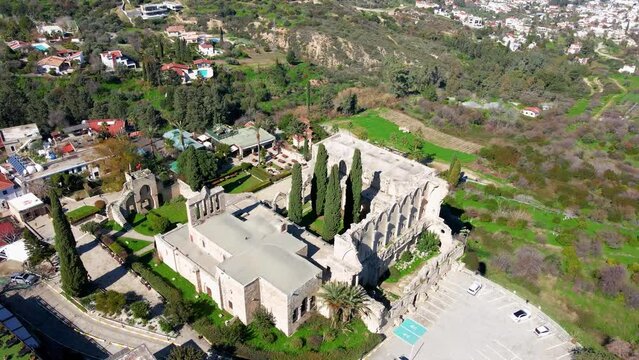 Aerial 4K view of beautiful Bellapais Village with Bellapais Monastery in Kyrenia, North Cyprus surrounded with an amazing green Mediterranean nature and picturesque landscapes in Cyprus.