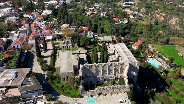Aerial 4K view of beautiful Bellapais Village with Bellapais Monastery in Kyrenia, North Cyprus surrounded with an amazing green Mediterranean nature and picturesque landscapes in Cyprus.