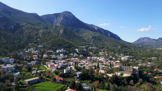 Aerial 4K view of beautiful Bellapais Village with Bellapais Monastery in Kyrenia, North Cyprus surrounded with an amazing green Mediterranean nature and picturesque landscapes in Cyprus.