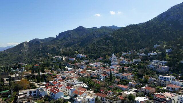 Aerial 4K view of beautiful Bellapais Village with Bellapais Monastery in Kyrenia, North Cyprus surrounded with an amazing green Mediterranean nature and picturesque landscapes in Cyprus.