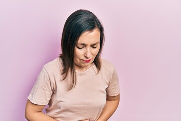 Fototapeta premium Middle age hispanic woman wearing casual clothes with hand on stomach because indigestion, painful illness feeling unwell. ache concept.