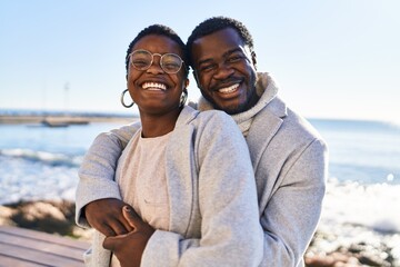 Man and woman couple hugging each other standing at seaside