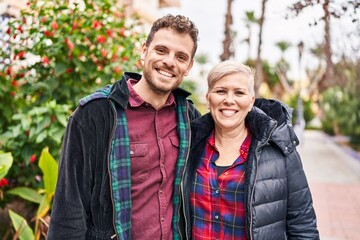 Mother and son smiling confident hugging each other at park