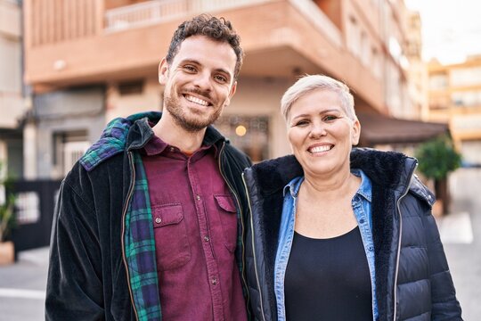 Mother and son smiling confident standing together at street