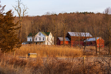 Large rural country home and red barn in dry winter landscape