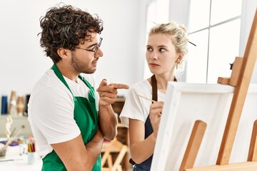 Paint teacher man teaching to student woman at art studio.