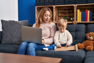 Mother and son using laptop and playing with abacus at home