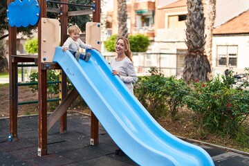 Mother and son playing on slide at park