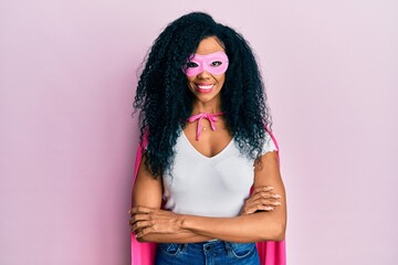 Middle age african american woman wearing super hero costume happy face smiling with crossed arms...