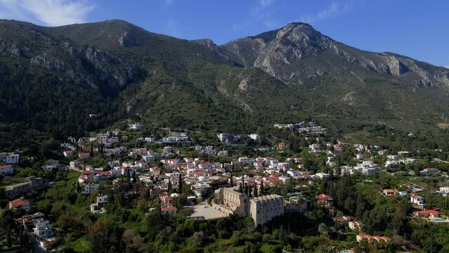Aerial 4K view of beautiful Bellapais Village with Bellapais Monastery in Kyrenia, North Cyprus surrounded with an amazing green Mediterranean nature and picturesque landscapes in Cyprus.