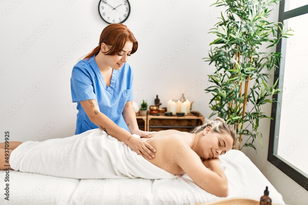 Poster woman couple smiling confident having back massage at beauty center