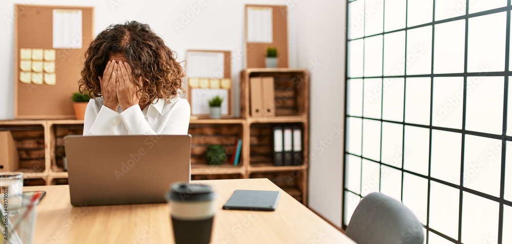 Poster Middle age hispanic woman working at the office wearing glasses with sad expression covering face with hands while crying. depression concept.