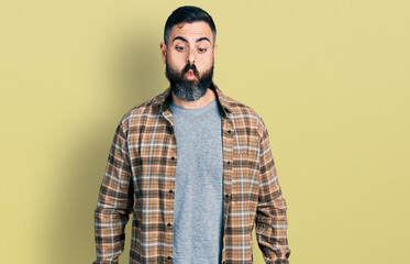 Hispanic man with beard wearing casual shirt making fish face with lips, crazy and comical gesture. funny expression.