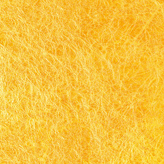 gold leaf foil background with shiny crumpled uneven surface for texture and background