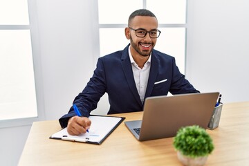 Young hispanic man smiling confident working at office