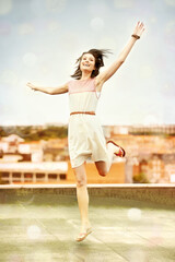 Living to the fullest. Pretty young woman dancing whimsically on a rooftop.