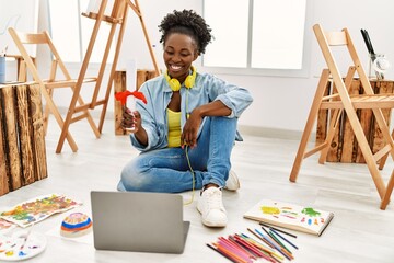 Young african american artist woman holding diploma at art studio.